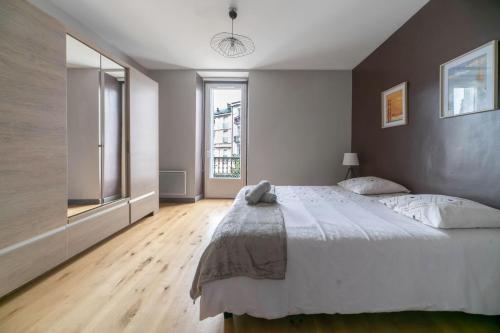 um quarto com uma cama grande e uma janela grande em Le Gramont - Grand appartement design, 3 chambres, Centre Ville em Vichy