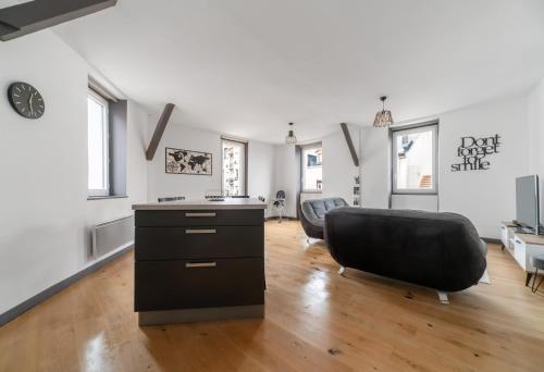 uma sala de estar com uma cadeira preta e uma secretária em Le Gramont - Grand appartement design, 3 chambres, Centre Ville em Vichy