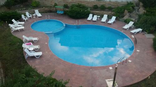 een uitzicht over een zwembad met stoelen en tafels bij Villa Rouge in Sozopol