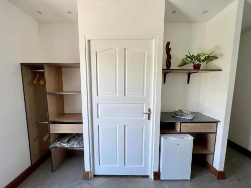 una porta bianca in una stanza con scaffali di Chambre Paradise a Lamentin