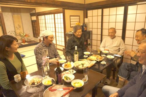 a group of people sitting around a table eating food at Aioi Yanto 一日一組限定古民家宿 in Otaru