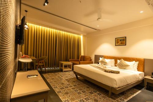 Habitación de hotel con cama y mesa en Krown Palace Resort, en Silvassa
