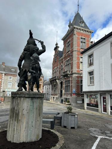 a statue of two people standing in front of a building at Impasse 1 in Fosses-La-Ville
