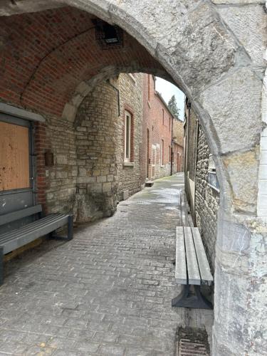 an empty alley with a bench in a brick building at Impasse 1 in Fosses-La-Ville