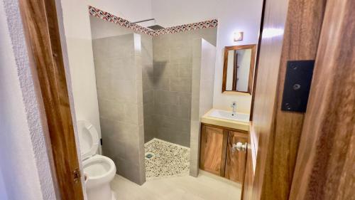 W łazience znajduje się prysznic, toaleta i umywalka. w obiekcie Casa Puerto Viejo w mieście Puerto Escondido