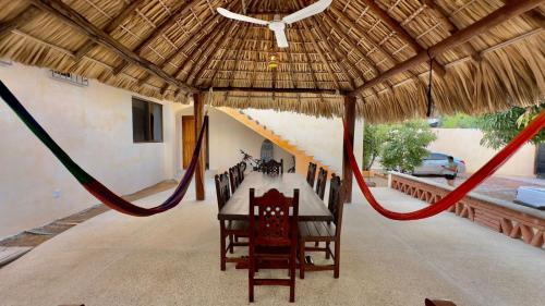 a table and chairs in a pavilion with a hammock at Casa Puerto Viejo in Puerto Escondido