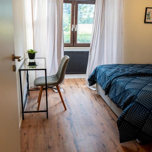 ein Schlafzimmer mit einem Bett, einem Tisch und einem Stuhl in der Unterkunft M Apartment Charme - gemütlich geräumig heimisch in Landau in der Pfalz