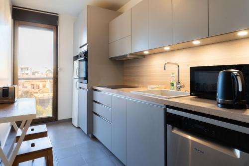 une cuisine avec des armoires blanches et un évier dans l'établissement L'Aérien- 2 Parking- Centre ville - Calme, à Toulouse