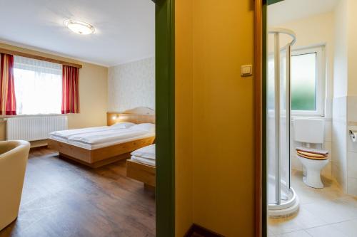 a hotel room with two beds and a bathroom at Gasthof zum Sessellift in Mitterbach