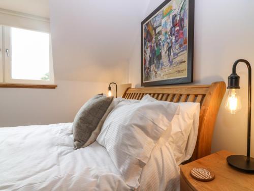 a bedroom with a white bed with two pillows at 15 Main Street in Peterhead