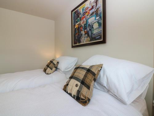 two beds in a bedroom with a picture on the wall at 15 Main Street in Peterhead