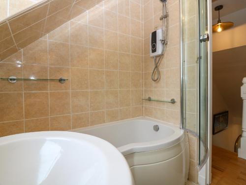a bathroom with a tub and a toilet and a shower at 15 Main Street in Peterhead