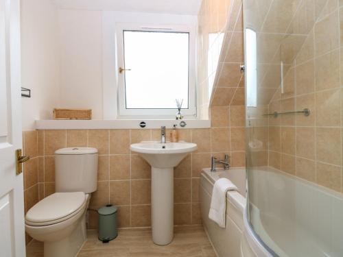 a bathroom with a toilet and a sink and a tub at 15 Main Street in Peterhead