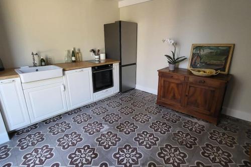 a kitchen with white cabinets and a sink and a stove at Villa les Tilleuls - Arènes de Béziers in Béziers