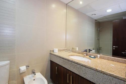 a bathroom with a sink and a toilet and a mirror at New Arabian - GOLDCREST in Dubai