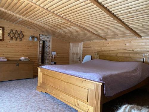 een slaapkamer met een bed in een houten hut bij Затишний будиночок біля річки in Krivorovnya