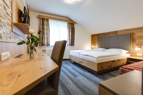 a hotel room with a bed and a table with flowers on it at Gasthof zum Sessellift in Mitterbach