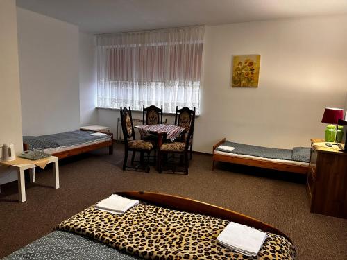 Habitación con cama con estampado de leopardo y mesa. en Pokoje Gościnne Impresja Kadzidło, en Kadzidło