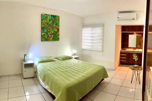 a bedroom with a bed and a painting on the wall at HERMOSA Y COMODA CASA " En condominio Privado " in Santa Cruz de la Sierra