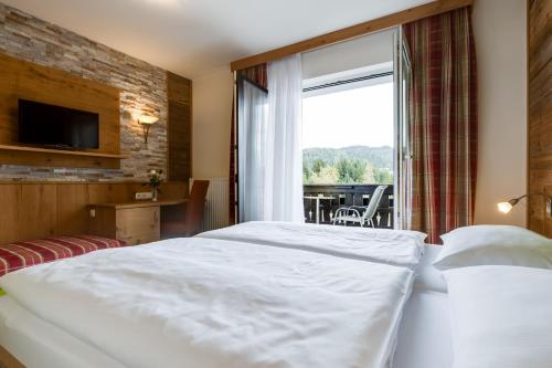 a hotel room with a bed and a large window at Gasthof zum Sessellift in Mitterbach