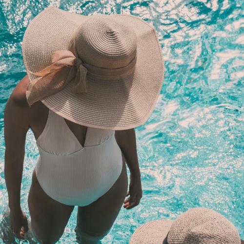 a woman in a straw hat standing in a swimming pool at MORF suites in Casale Marittimo