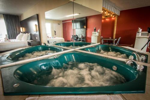 een groot bad gevuld met bubbels in een hotelkamer bij Envi Boutique Hotel in Henderson