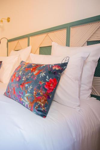 a pillow on top of a bed with white pillows at Le Pavillon de la Kasbah & SPA Marrakech in Marrakech