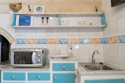 a kitchen with a sink and a microwave at San Leonardo - ApartHotel in Laterza