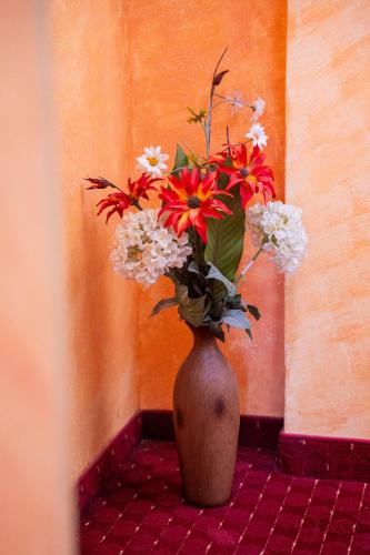 a vase filled with flowers sitting on a tile floor at Hotel Cantemir in Bucharest