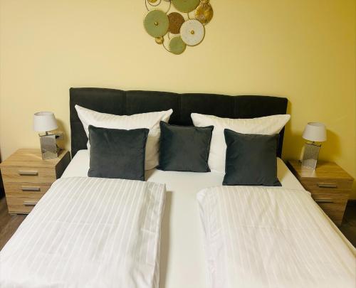 a bedroom with two beds with pillows and a clock on the wall at Hotel & Restaurant Olio é Pane in Enzklösterle