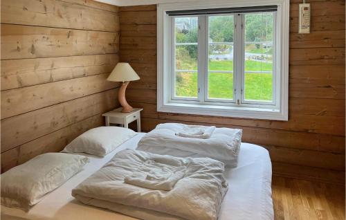 5 Bedroom Amazing Home In Suldalsosen في Suldalsosen: سريرين في غرفة مع نافذة