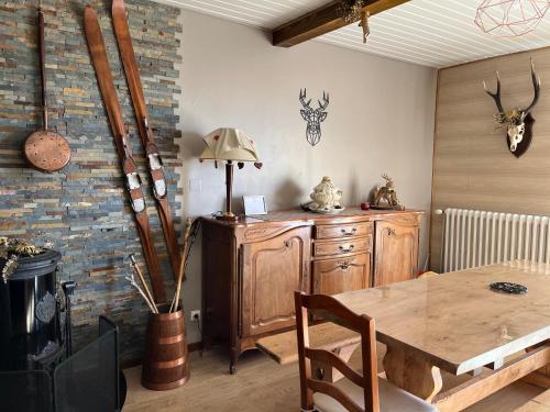une salle à manger avec une table en bois et un mur en briques dans l'établissement Grand F3 75m2 4/6 pers, jardin terrasse, top vue, à Font-Romeu-Odeillo-Via