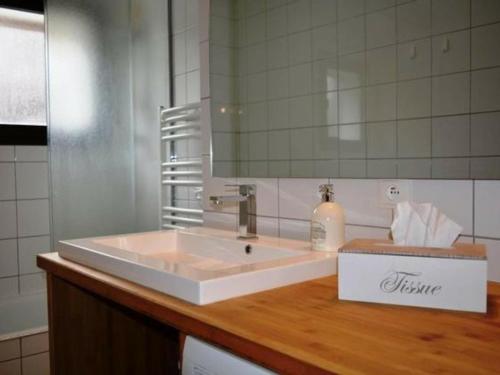 une salle de bain avec un lavabo blanc et un miroir dans l'établissement Appartement 3 chambres au pied des pistes avec balcon - Le Grand-Bornand - FR-1-467-59, au Grand-Bornand