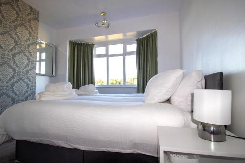 1 dormitorio con 1 cama blanca grande y ventana en Fully renovated spacious home, Sleeps 5, en Grantham