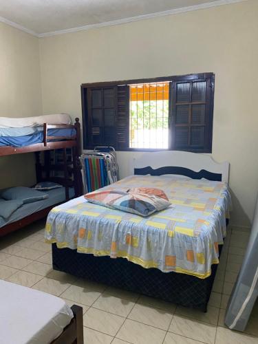 a bedroom with a bed and bunk beds in it at Casa em frente à praia Boracéia in Boracéia