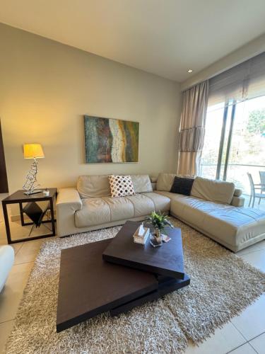 Abdoun Falls Luxury Apartment في عمّان: غرفة معيشة مع أريكة وطاولة