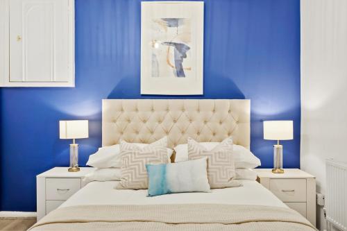 a blue bedroom with a large bed with blue walls at Luxury 1 Bed Retreat With Free Parking - FREE NETFLIX & WIFI in Chatham