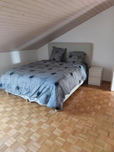 1 cama en un dormitorio con suelo de madera en 2p1/2 proche de la gare en Fribourg