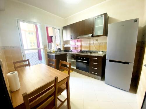 eine Küche mit einem Tisch und einem weißen Kühlschrank in der Unterkunft Appartement Complète à Tanja balia proche de la mer in Tangier