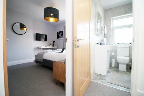 a bedroom with a bed and a bathroom at Maindy House - Home close to City Centre + parking in Cardiff