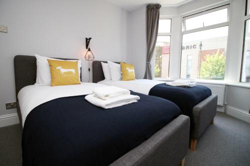 a bedroom with two beds with towels on them at Maindy House - Home close to City Centre + parking in Cardiff