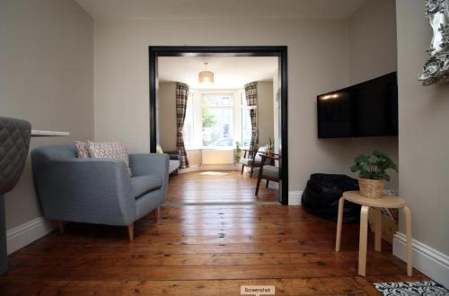 a living room with a blue chair and a couch at Maindy House - Home close to City Centre + parking in Cardiff
