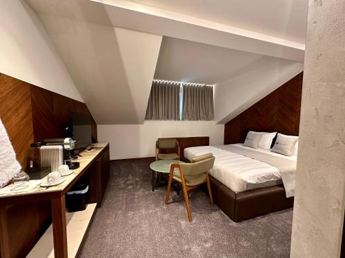a hotel room with a bed and a desk at Hôtel Restaurant & Spa Les Planets in Les Rasses