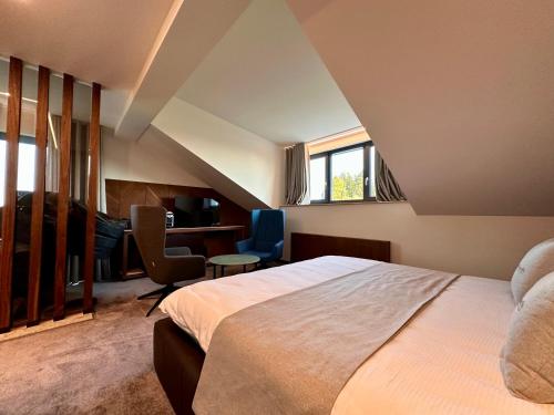 een slaapkamer met een bed, een bureau en een stoel bij Hôtel Restaurant & Spa Les Planets in Les Rasses