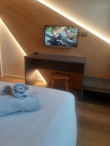 sypialnia z łóżkiem i biurkiem z telewizorem w obiekcie Appartamento Vale e Schena Cortina D'Ampezzo w mieście San Vito di Cadore