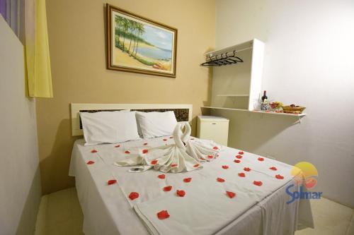 a bedroom with a bed with red hearts on it at Pousada Solmar in Japaratinga