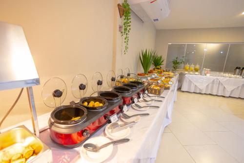 a buffet line with many dishes of food on it at Hotel BHS in Linhares