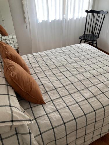 拉普拉塔的住宿－Meridiano Alquiler Temporario，卧室内的一张带枕头的床铺和一把椅子