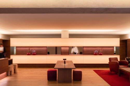 a waiting room with a table and chairs at Vigilius Mountain Resort in Lana