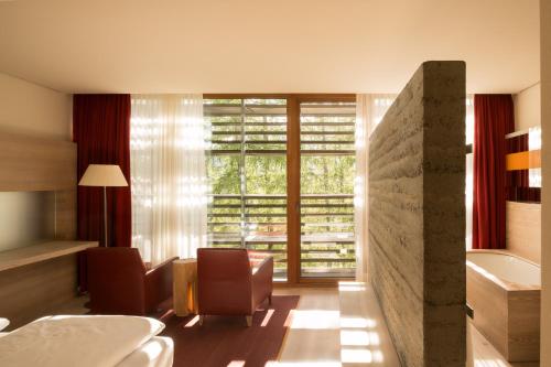 a bedroom with a bed and a large window at Vigilius Mountain Resort in Lana